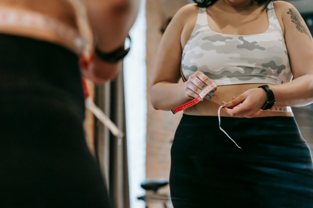woman trying to measure her waist - wondering how to lose weight without workout