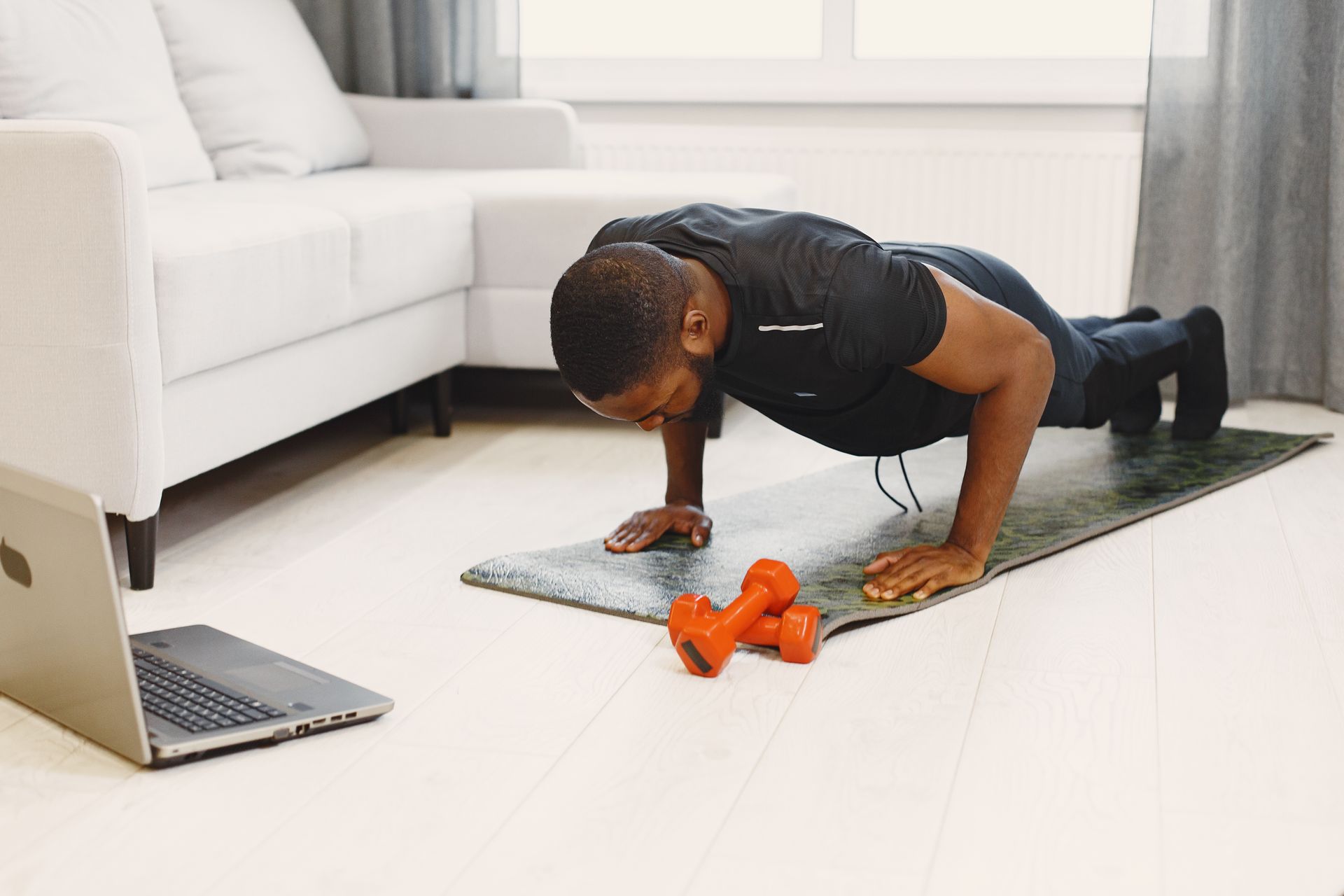 Man in black activewear doing push-ups at home
