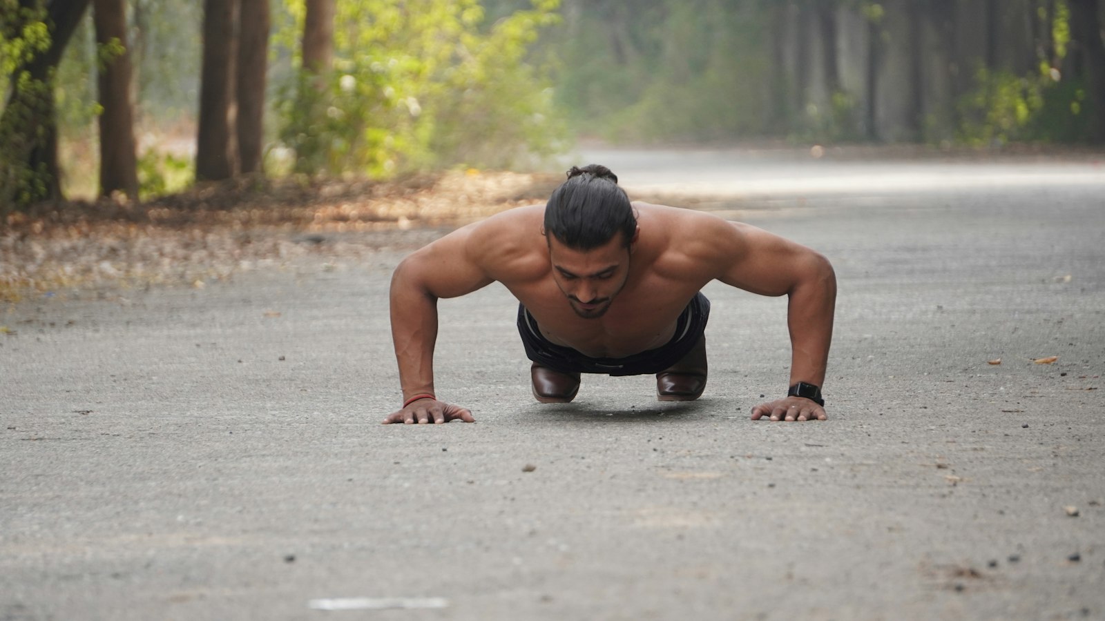 Man doing push-ups outdoors on a road