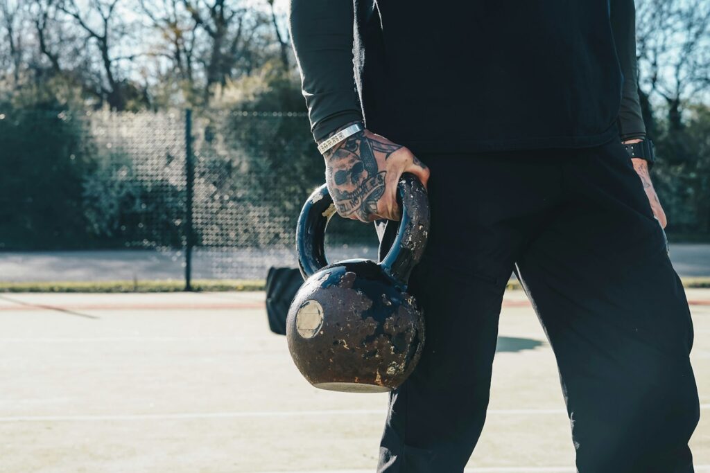 Man holding a kettlebell for goblet squats outdoors