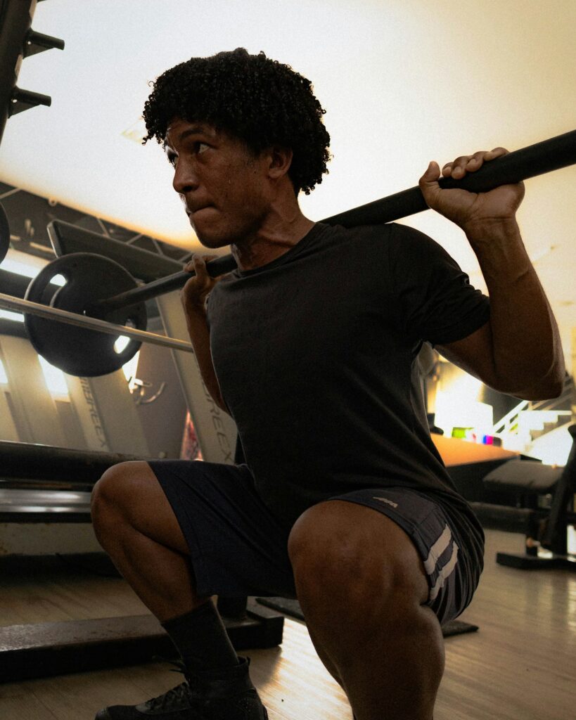 Man doing a deep barbell back squat in the gym