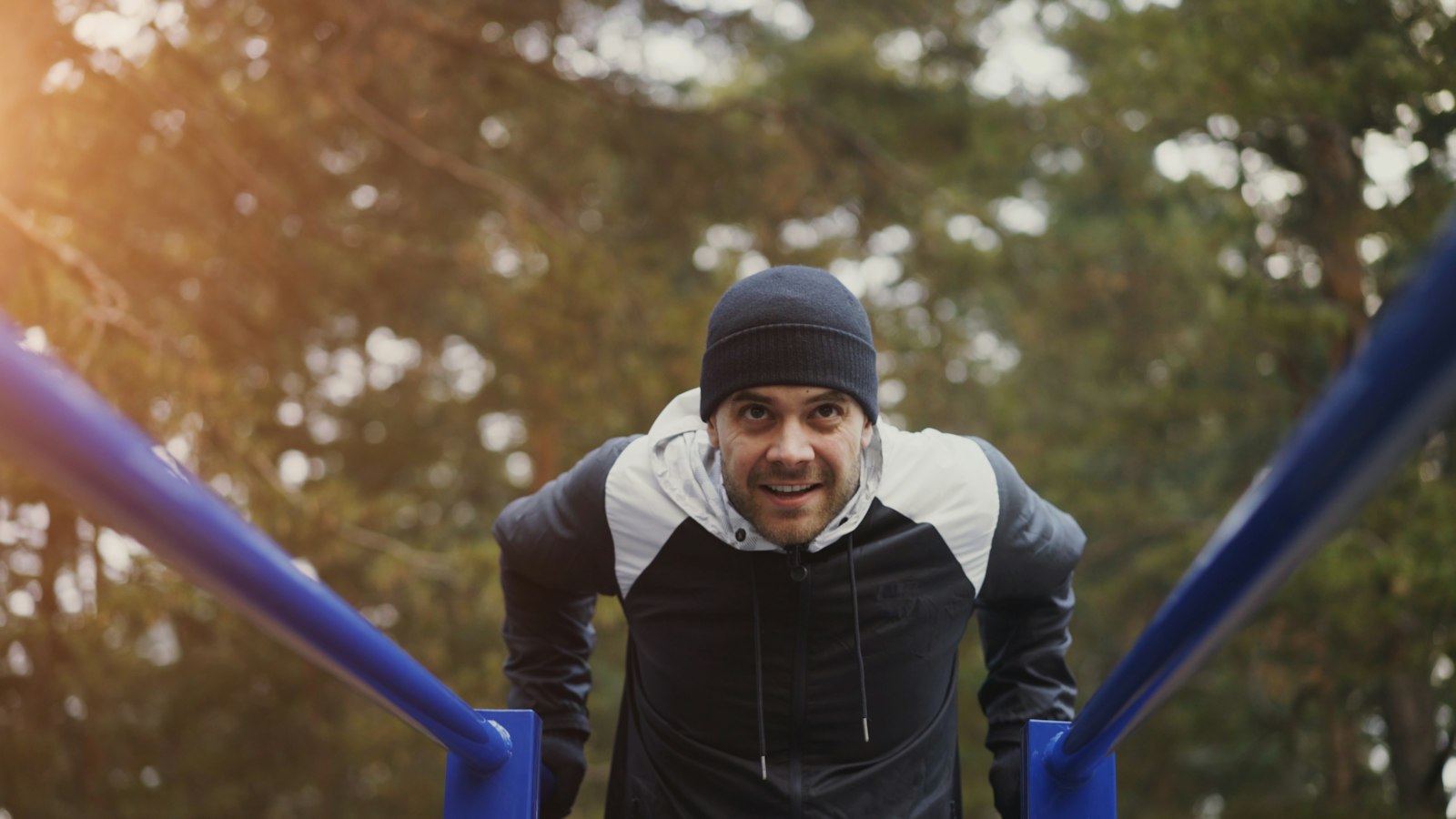 Man doing dips on outdoor parallel bars