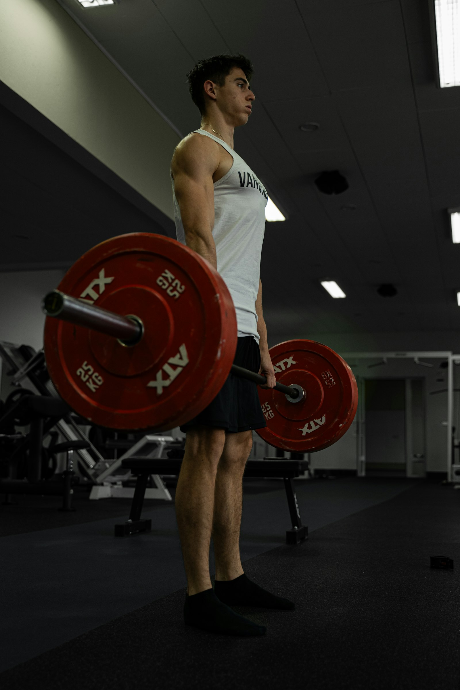 Man standing tall holding a barbell in the starting position